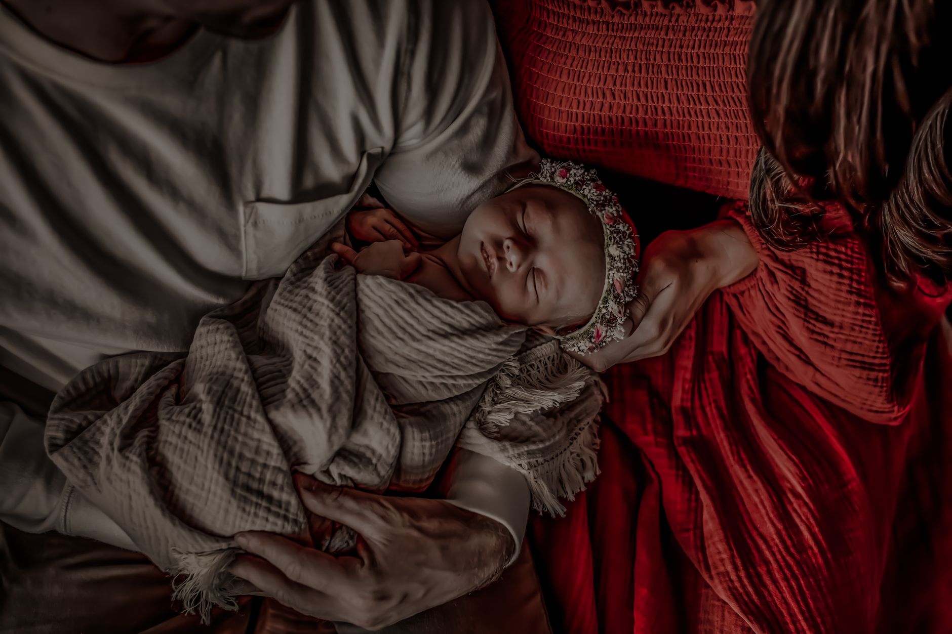 Ilustrasi: A warm family moment with parents lovingly holding their sleeping newborn baby.