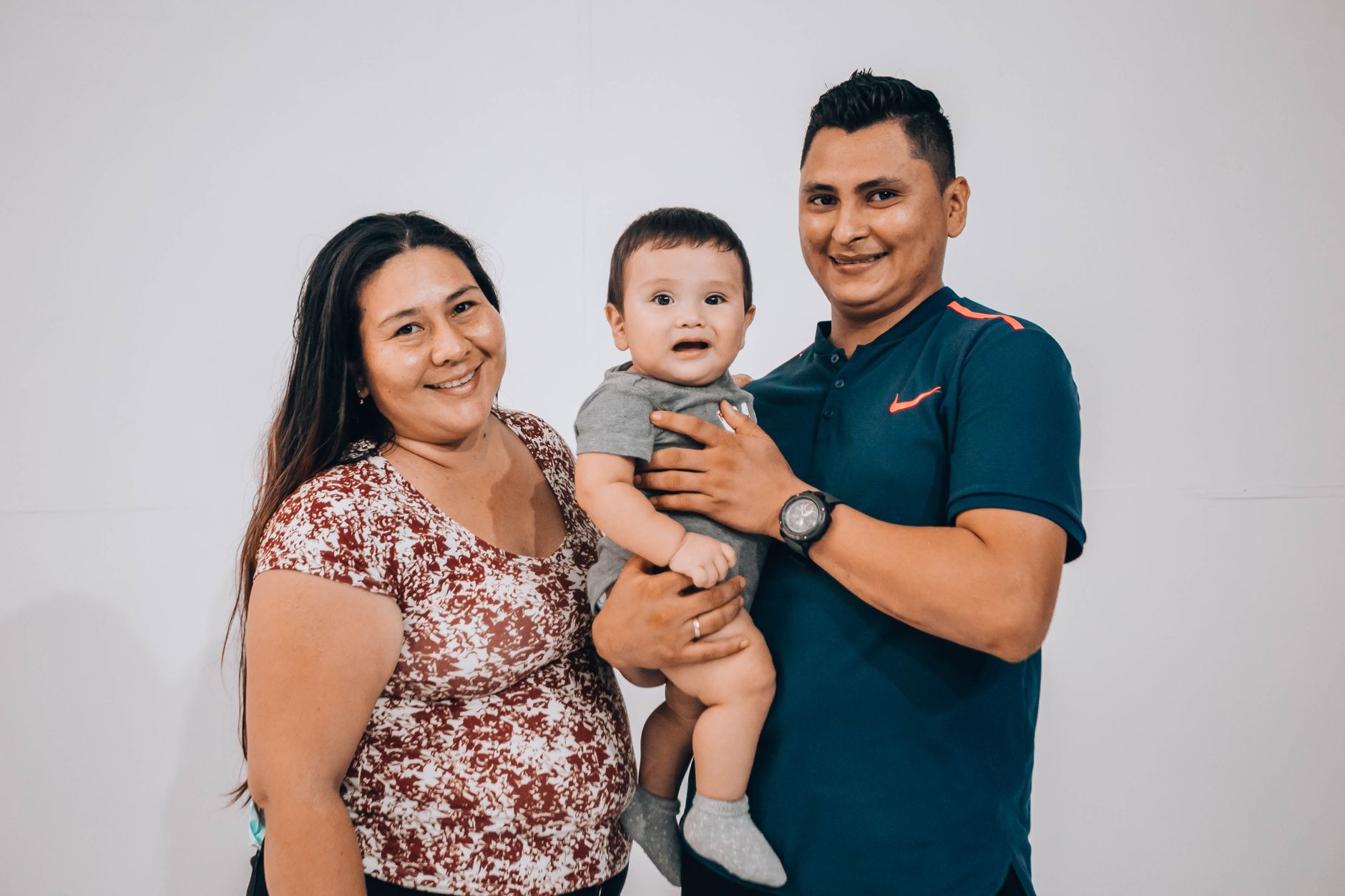 Ilustrasi: Happy parents holding their baby boy during a studio photoshoot.