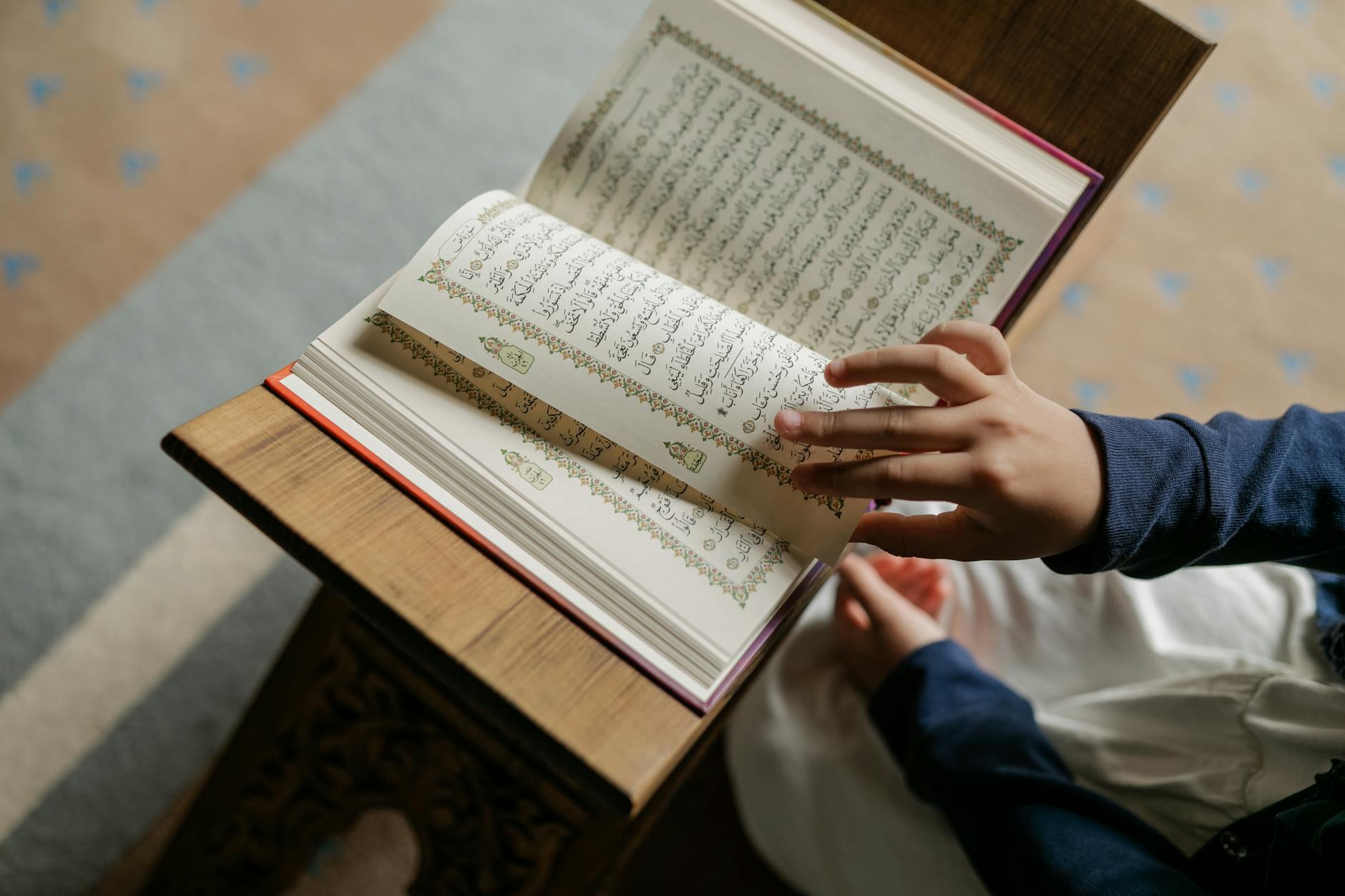 Ilustrasi: Child wearing hijab reading the Quran indoors, symbolizing Islamic culture.