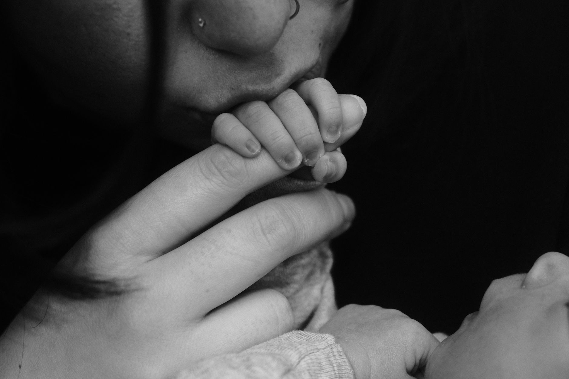 Ilustrasi: A close-up black and white photo capturing the tender bond between a mother and her baby through hands holding.