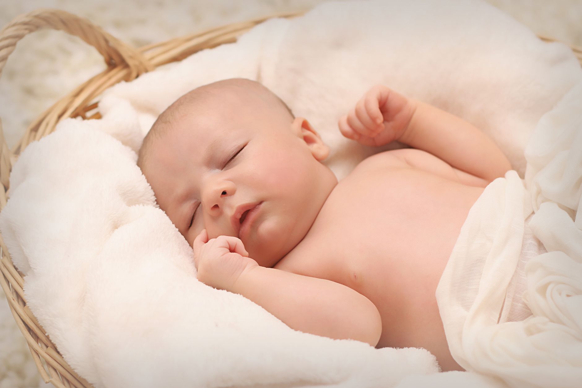 Ilustrasi: A peaceful sleeping baby nestled in a soft, fluffy blanket inside a wicker basket.