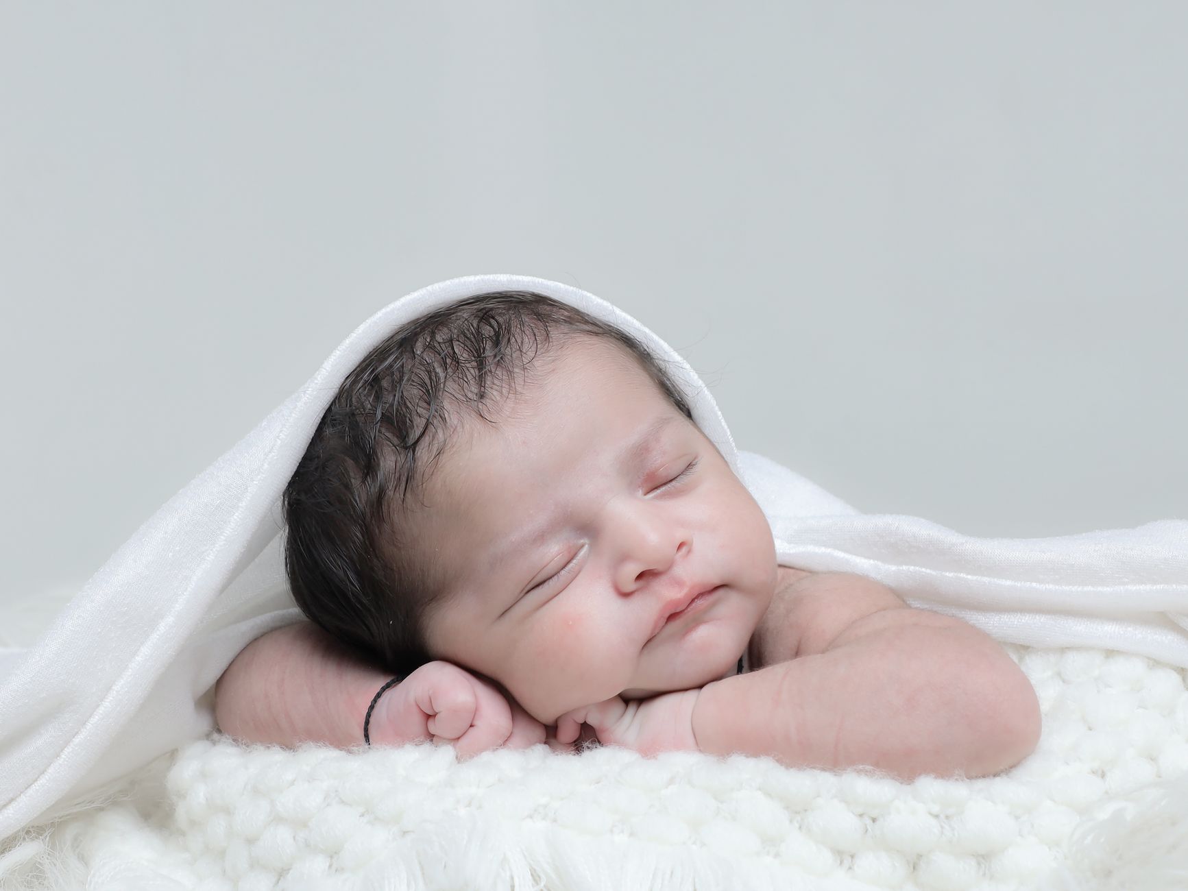 Ilustrasi: A peaceful newborn baby sleeping, wrapped in a soft white blanket. Perfect for family and parenting themes.