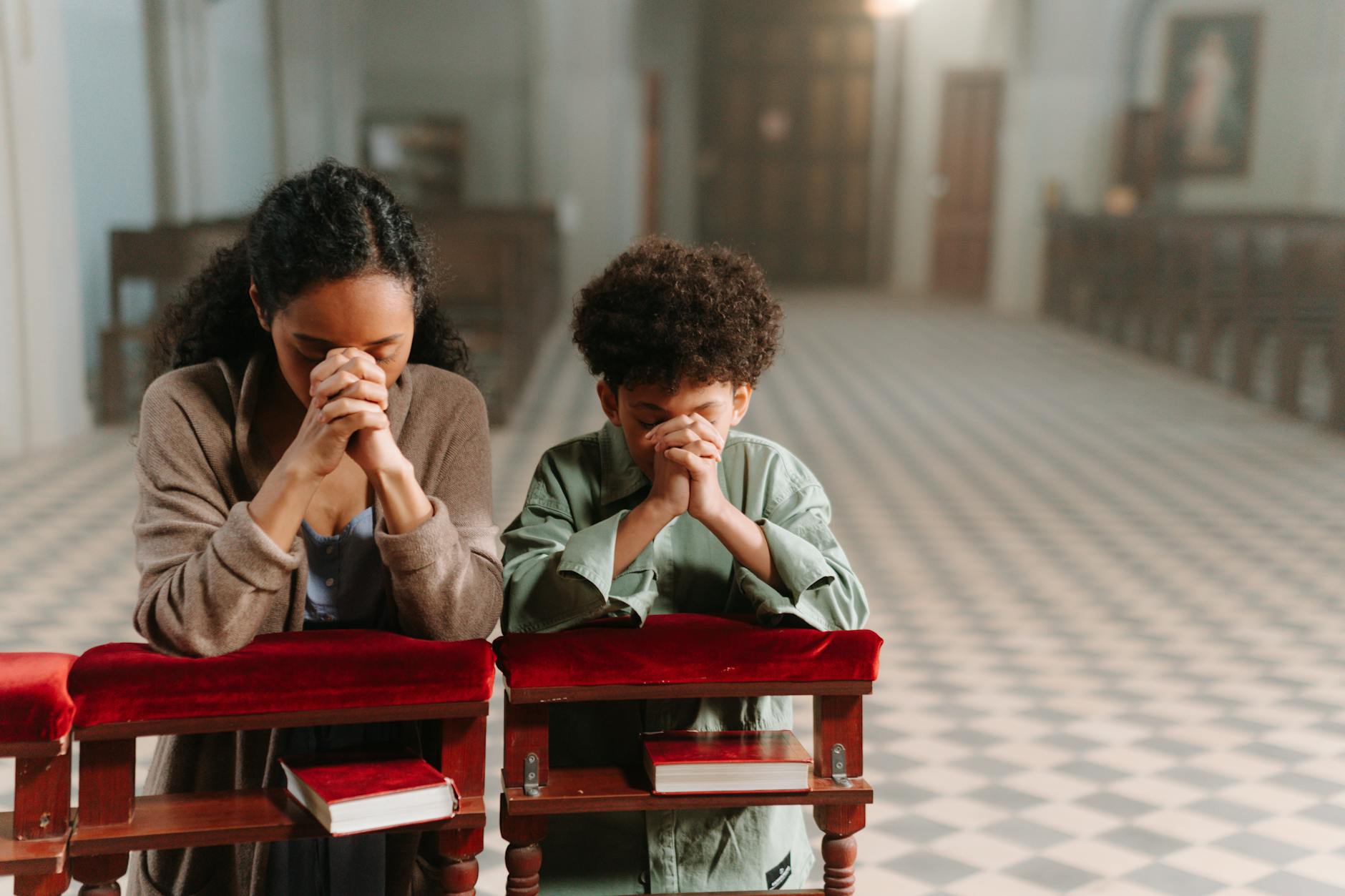 Ilustrasi: A mother and son kneeling and praying together inside a serene church.