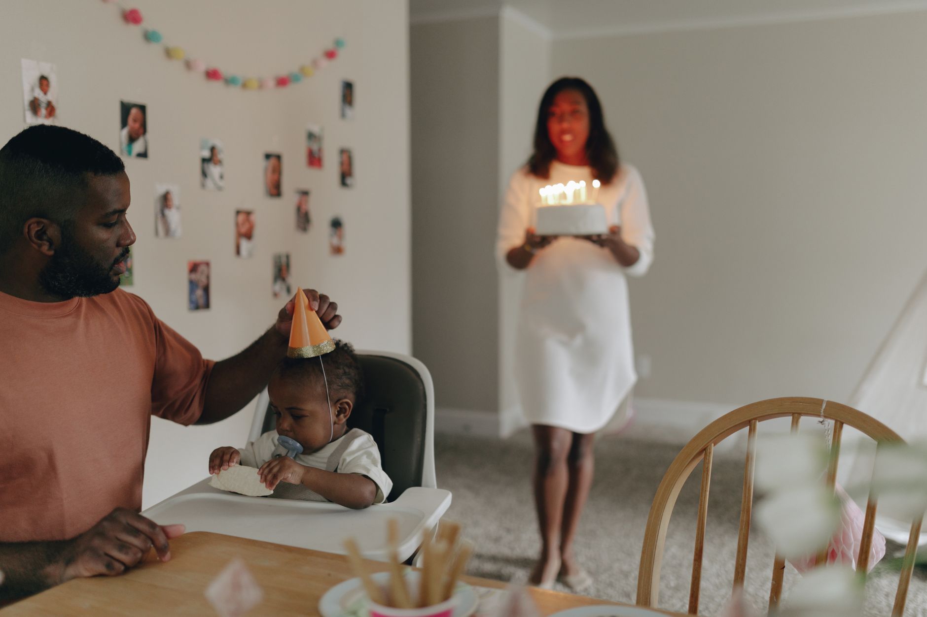 Ilustrasi: A joyful family celebrating a baby's first birthday with cake and decorations.