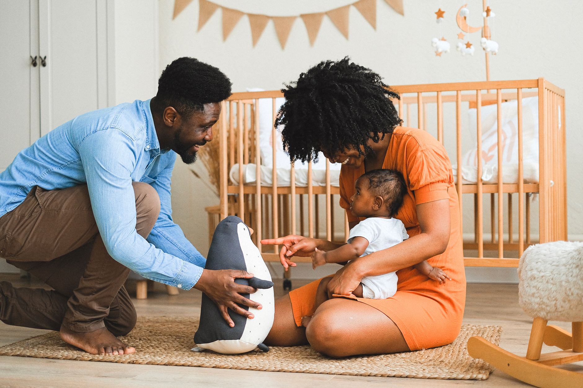 Ilustrasi: Cheerful parents bonding with baby in modern nursery, experiencing precious moments.