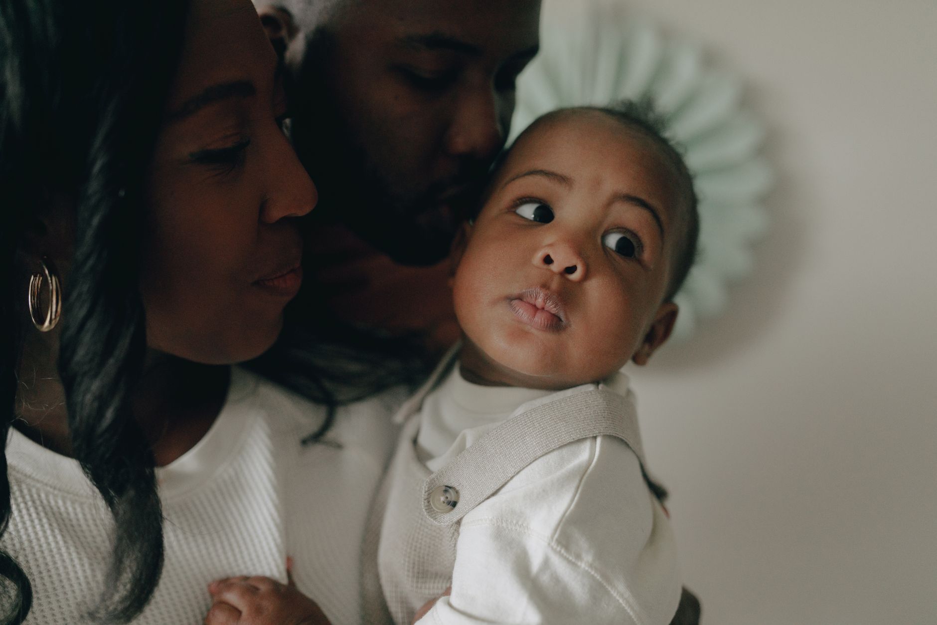 Ilustrasi: Close-up of a joyful African American family sharing a tender moment with their baby.