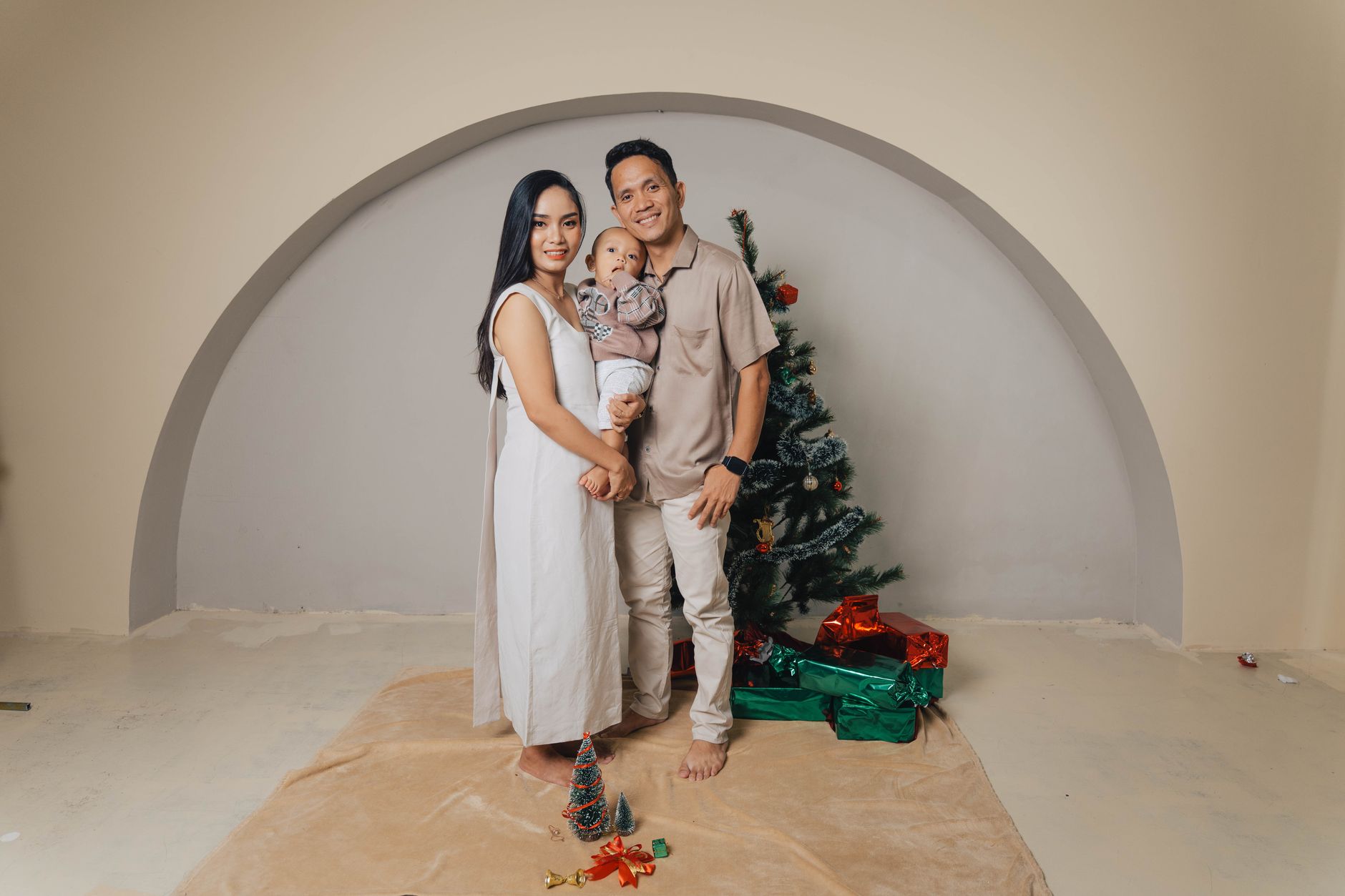 Ilustrasi: Happy family posing with Christmas tree and gifts indoors. Modern holiday celebration.