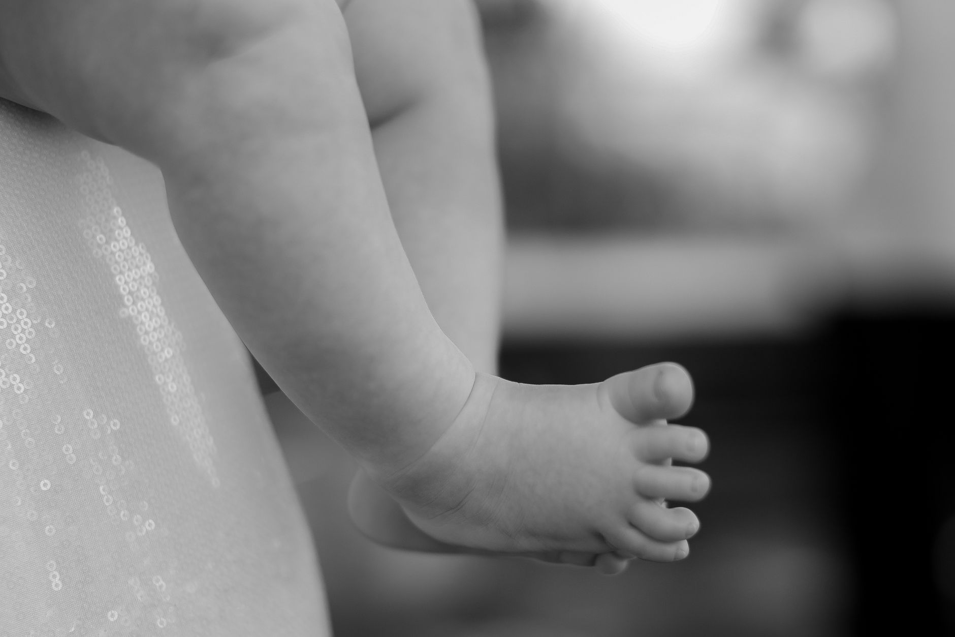 Ilustrasi: Artistic black and white close-up of a baby's foot, capturing innocence and detail.