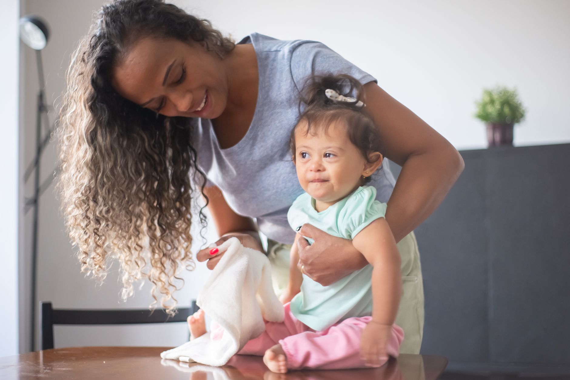 Ilustrasi: A happy mother and baby bonding in a cozy indoor setting, highlighting family love and care.