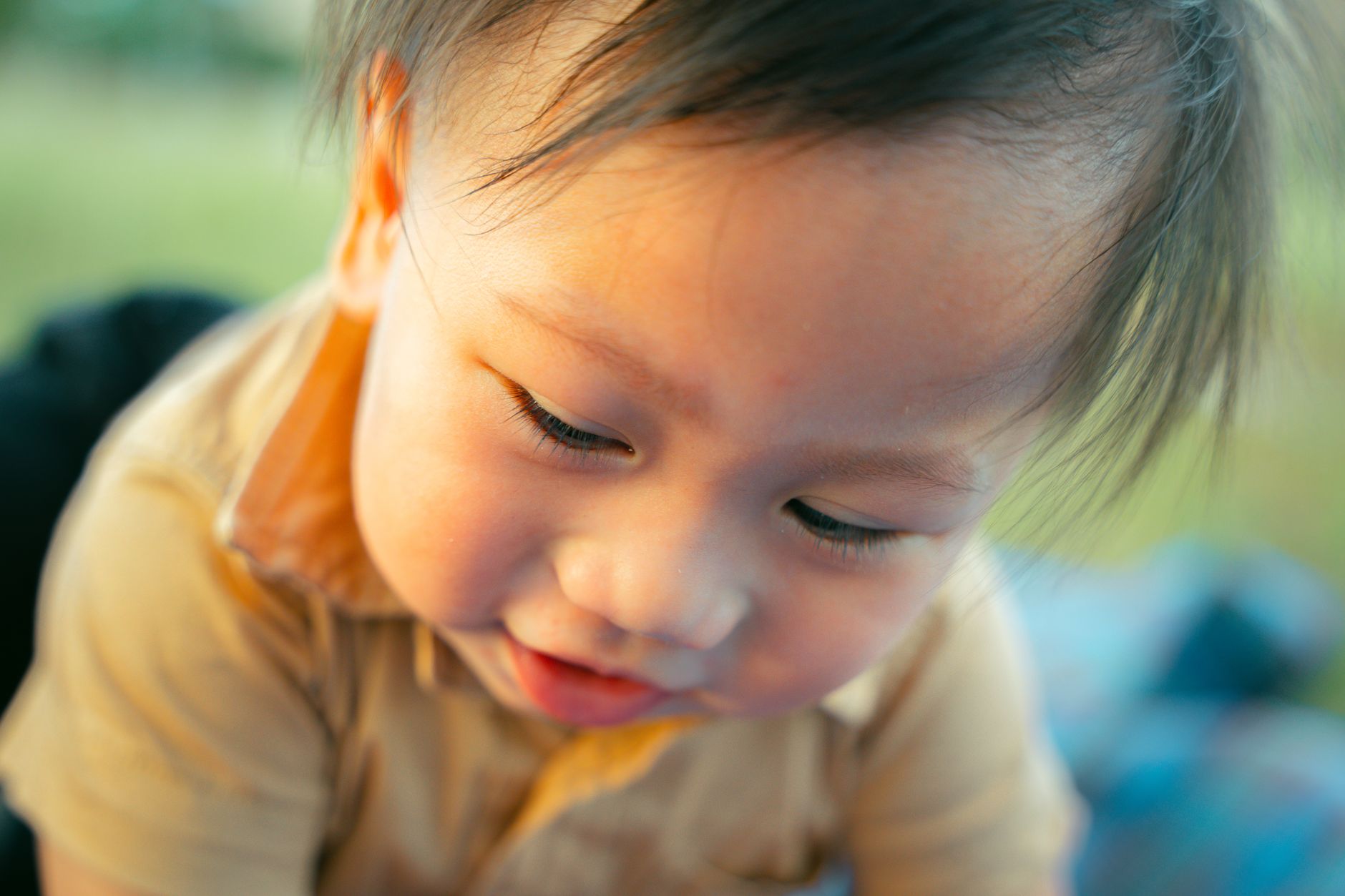 Ilustrasi: Close-up of a cute baby boy bermain outdoors on a sunny day, capturing joyful innocence.