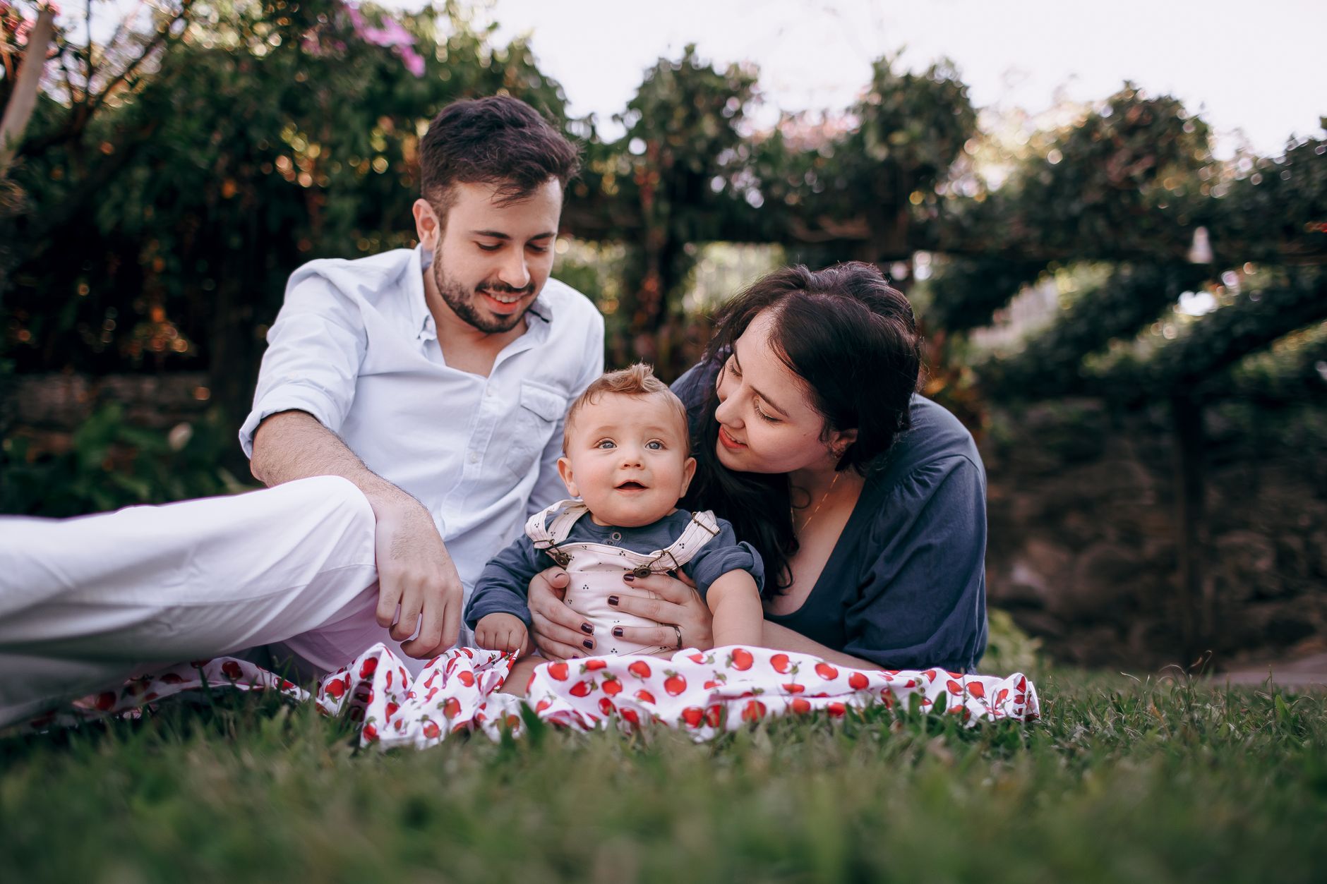 Ilustrasi: A young family with a baby enjoys a relaxing outdoor picnic on a warm sunny day, surrounded by nature.