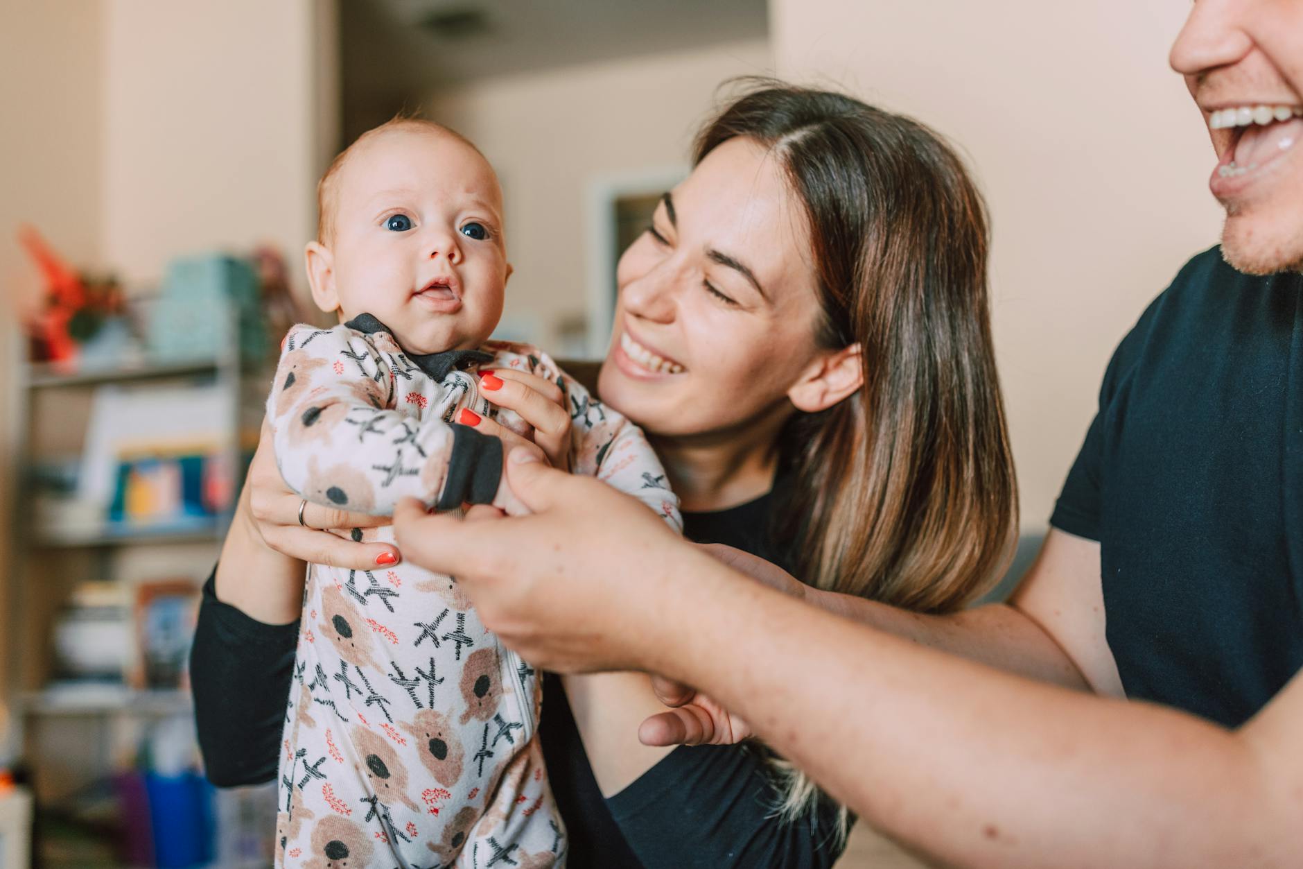 Ilustrasi: A joyful family moment with parents holding their baby indoors, showcasing love and togetherness.
