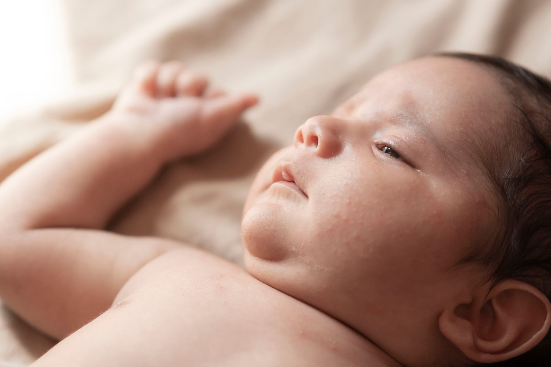 Ilustrasi: Gentle close-up portrait of a newborn baby lying down, capturing innocence and tranquility.