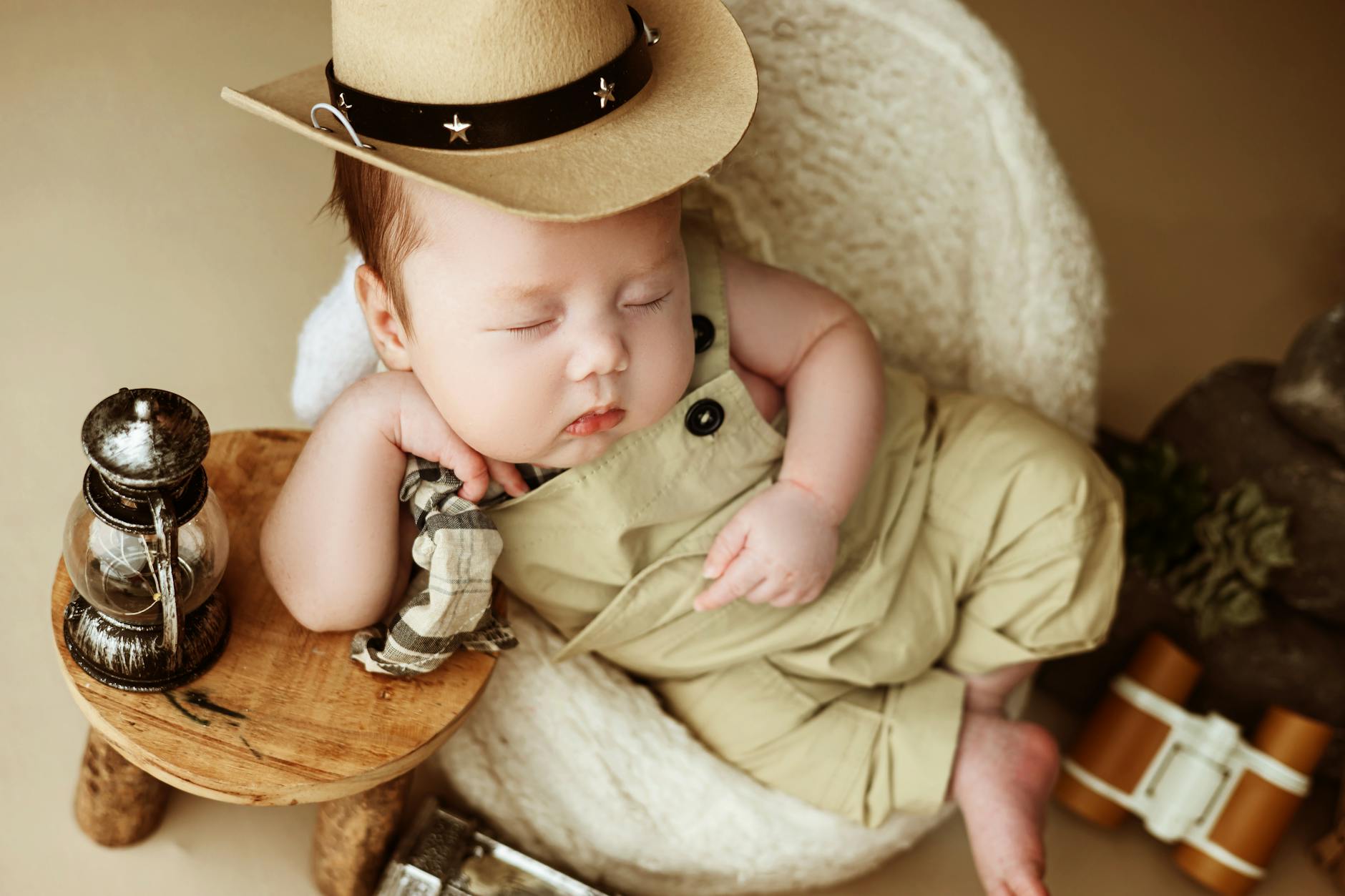 Ilustrasi: Cute baby in a cowboy hat sleeping peacefully with vintage decor.
