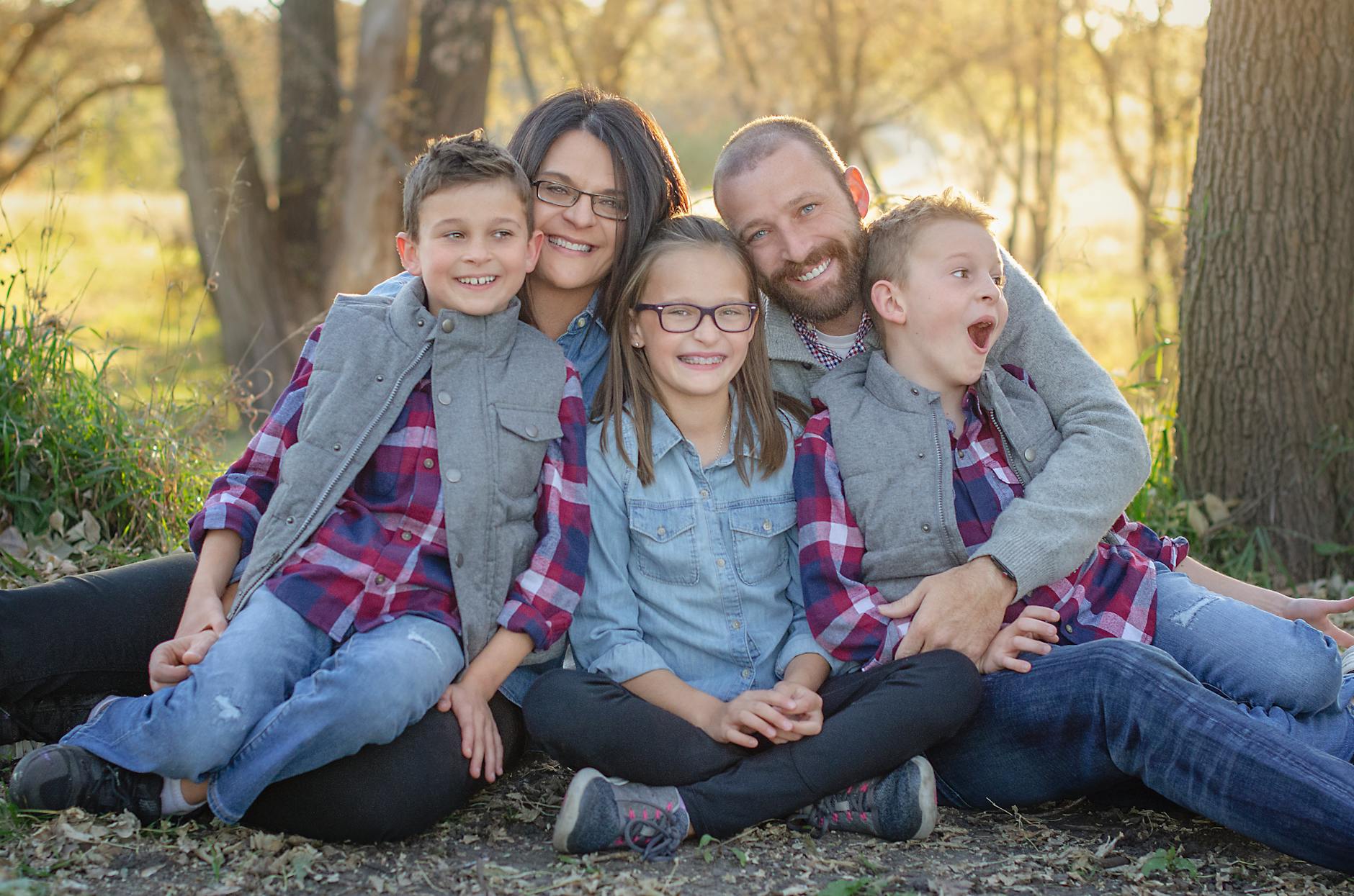 Ilustrasi: A joyful family portrait in matching outfits enjoying a sunny day outdoors.