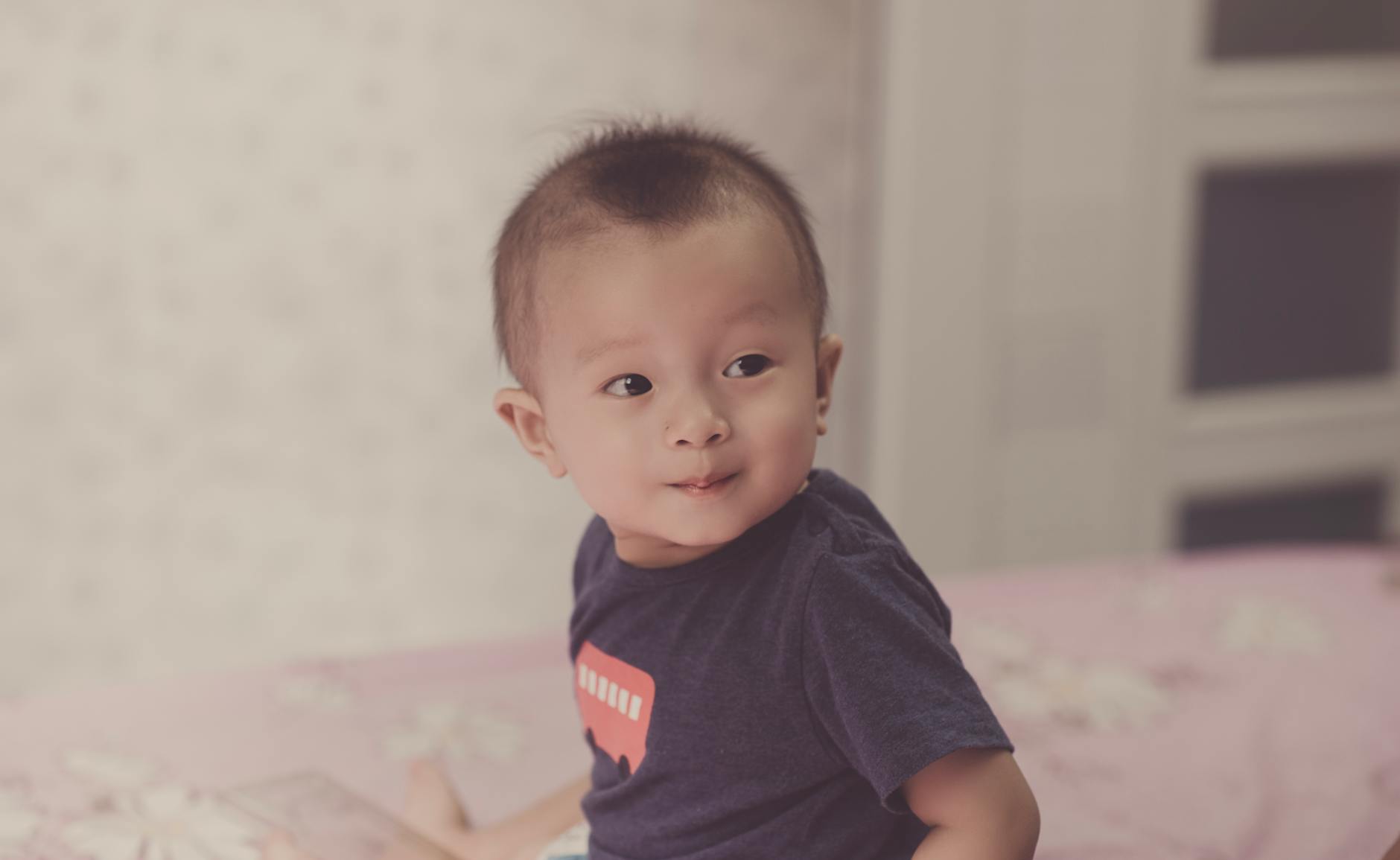 Ilustrasi: Charming portrait of a baby boy with curious expression captured indoors.